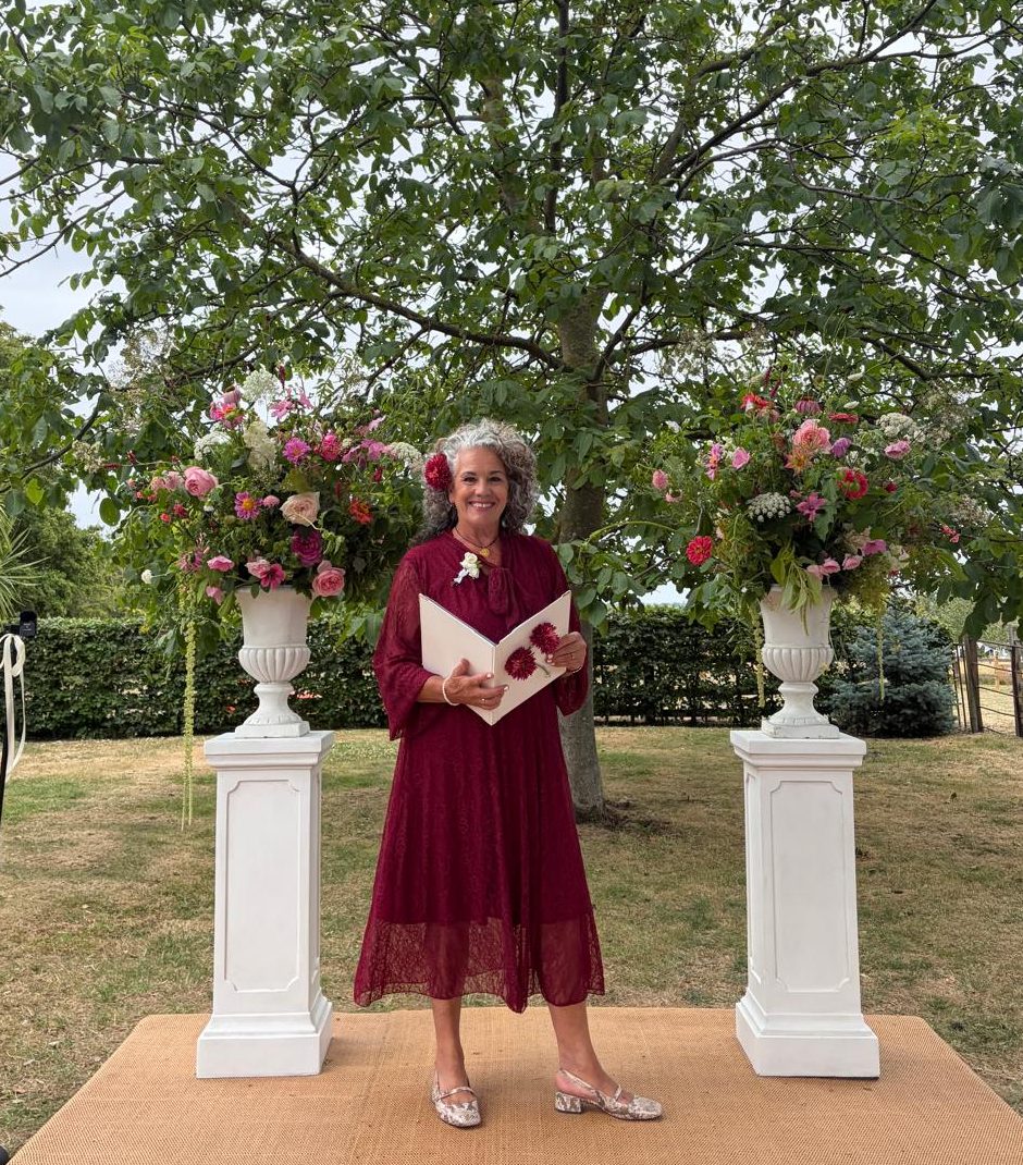 Leah leading a garden wedding ceremony between two flower stands