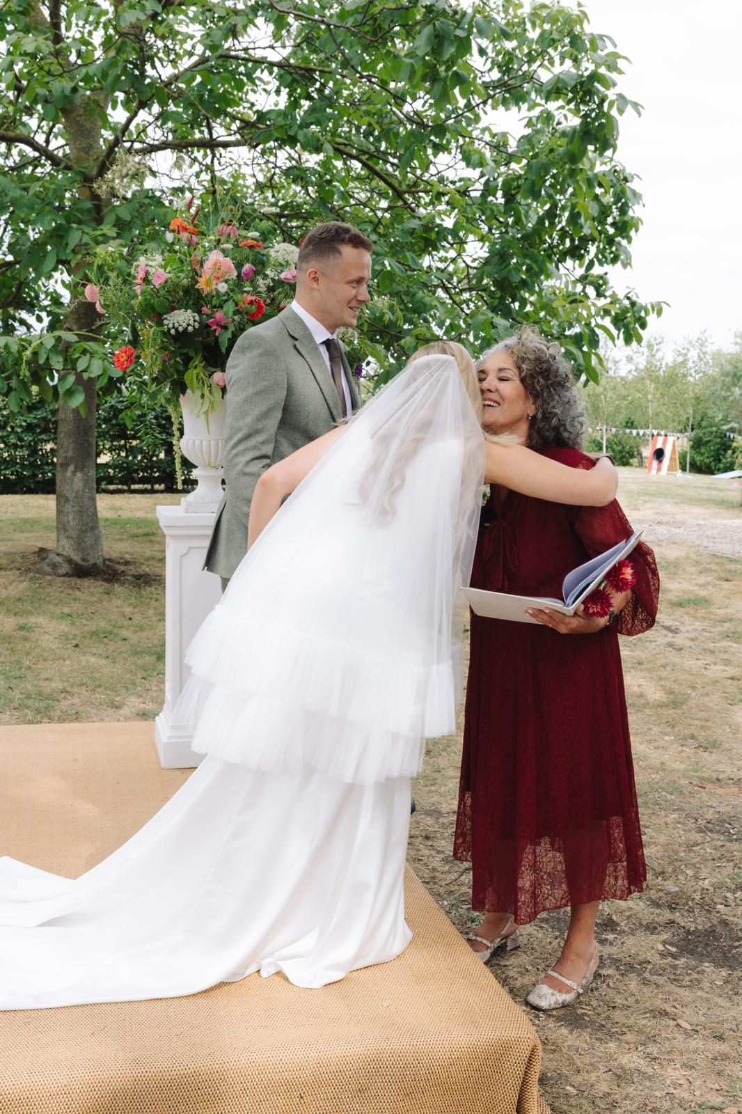 Leah hugging the bride after a garden wedding